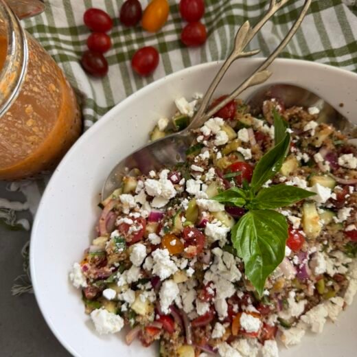 Mediterranean quinoa salad with sun dried tomato vinaigrette in a white bowl