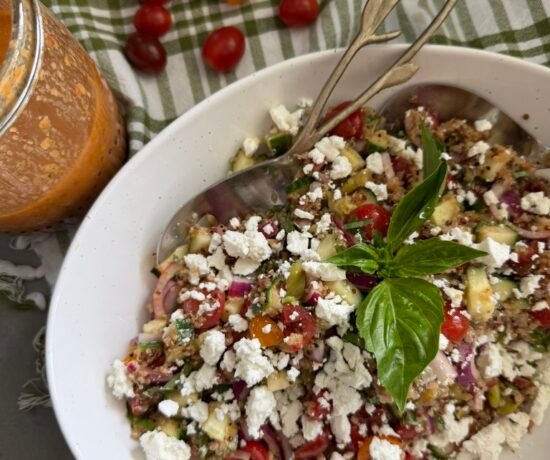Mediterranean quinoa salad with sun dried tomato vinaigrette in a white bowl