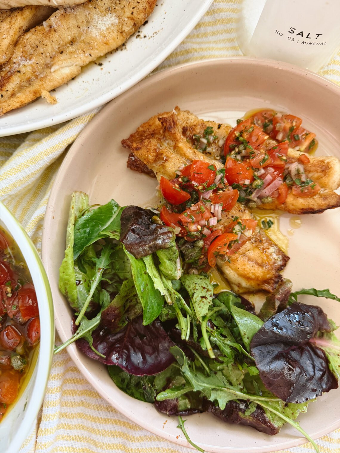 Pan seared snapper with fresh vierge sauce on a cream plate