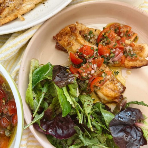Pan seared snapper with fresh vierge sauce on a cream plate