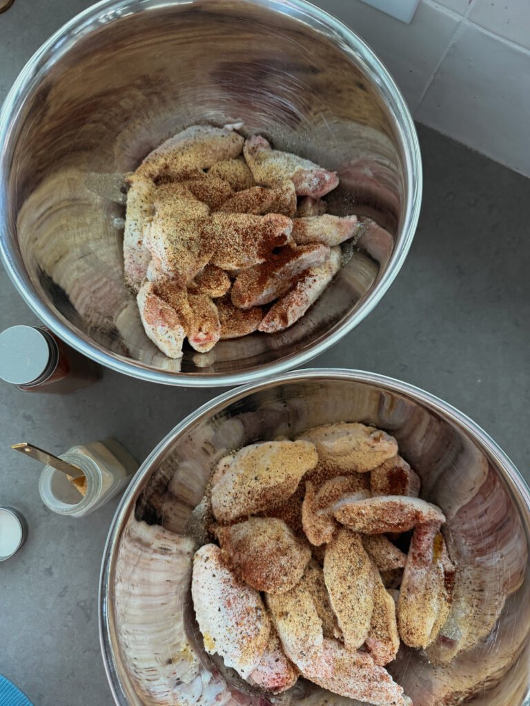 seasoning chicken wings in a bowl